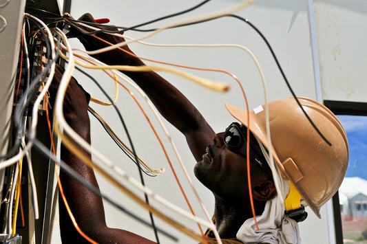 Electrician working on panel and identifying wires with labels